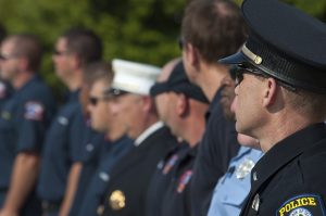 Image is a close up of a line of police officers standing outside.