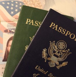 Image is of a group of American passports, one open and two closed.
