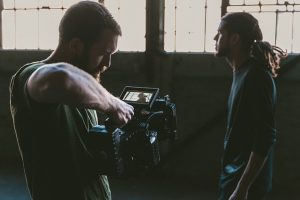 Image is of a man filming another man.