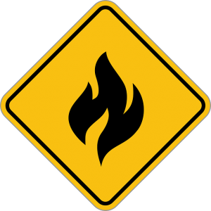 Image is a yellow caution sign with a black flame painted on it.