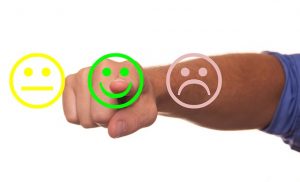 Image is of neutral, happy, and sad smiley faces with a man's finger pointing at the smiley face.