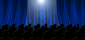 Image is an illustration of an audience looking at a blue theater curtain.