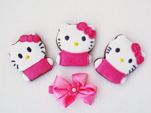 Image is of three Hello Kitty gingerbread cookies above a pink bow.