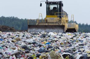 Image is a bulldozer working in a landfill.