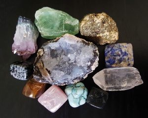 Image is a group of rough gemstones against a black background.