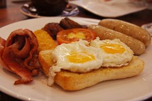 Image is a plate of bacon, eggs, toast, and sausage.