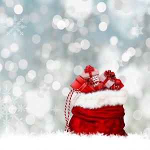 Image is a red gift bag full of wrapped presents against a silver glitter background.