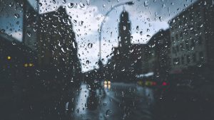Image is a city skyline seen through a rainy window.