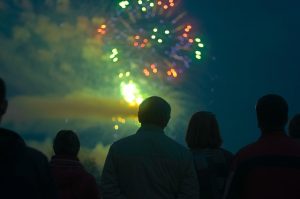 Image is a group of people watching a fireworks show.