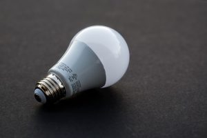 Image is a plain LED light bulb lying on a black table top.