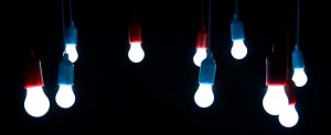 Image is a group of LED light bulbs hanging from a string against a black background.
