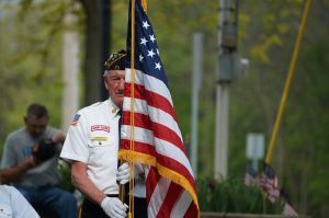 Image is a Veteran Holding an American Flag.