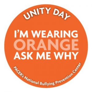 Image is an illustration of a badge that says "Unity Day I'm wearing Orange Ask Me Why."