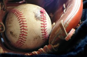 Image is a close up of a softball in a glove.
