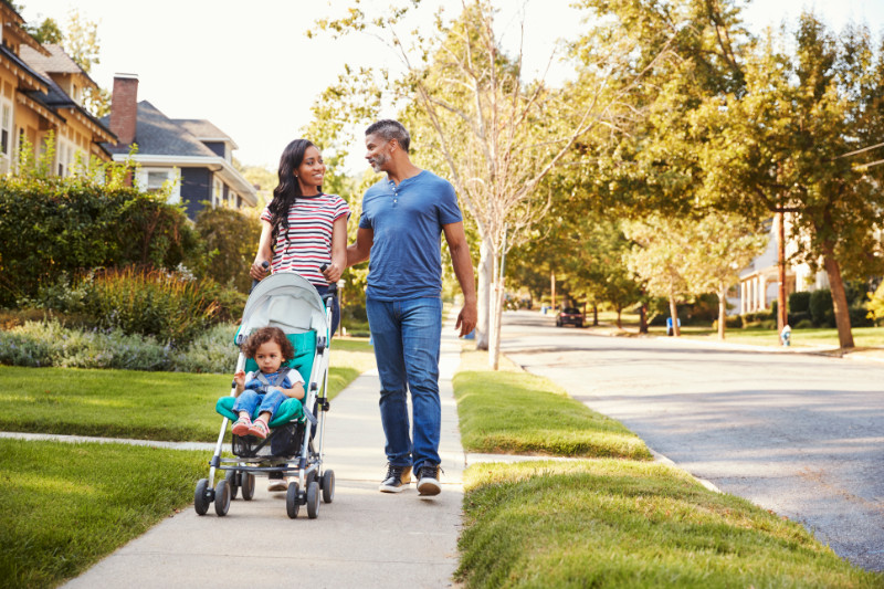 A couple taking a walk with their child in a stroller