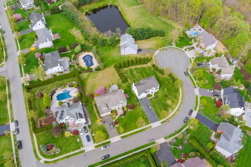 flight with a drone over a house in small town on a sunny day