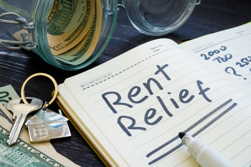 rent relief sign and almost empty jar with money